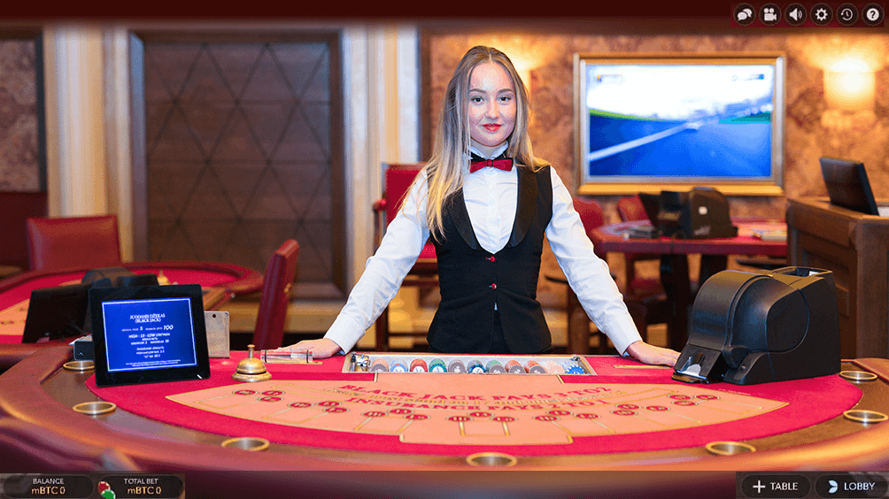 A live dealer at a blackjack table in an online casino.