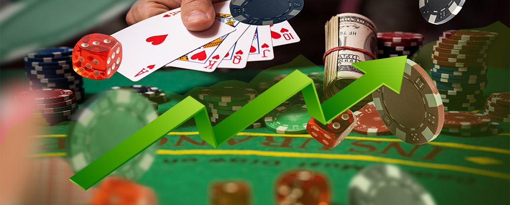 A casino table with playing cards, dice, playing chips and a green ascending arrow