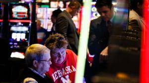 Woman wearing University of Nebraska sweatshirt while playing Slots at the Ponca tribe's Prairie Flower Casino