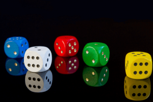 A reflection of five dices all in different colors. Blue, white, red, green and yellow