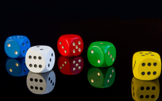 A reflection of five dices all in different colors. Blue, white, red, green and yellow
