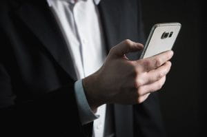 Man in suit holding a smartphone