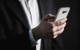 Man in suit holding a smartphone