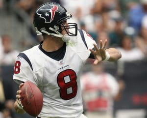 A quarterback wearing number 8 in a white Houston Texans uniform and navy blue helmet prepares to throw a pass