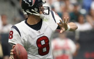 A quarterback wearing number 8 in a white Houston Texans uniform and navy blue helmet prepares to throw a pass