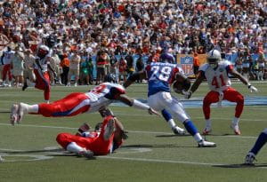 Running back Adrian Peterson in a blue uniform rushes with the football against the defensive players wearing white uniforms