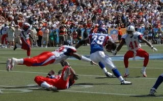 Running back Adrian Peterson in a blue uniform rushes with the football against the defensive players wearing white uniforms