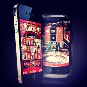 Two mobile devices, an iPhone and Android phone, displaying an online casino mobile, including online Slots and online Roulette.