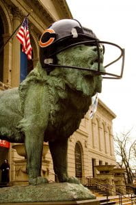 A lion statue outside of the art museum in Chicago wearing a Chicago Bears football helmet
