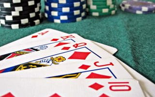 A Royal Flush in diamonds on the felt of a poker table to represent Online Poker popularity in Pennsylvania.