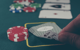 A poker player’s cards along with his chips, the pot, and the flopped cards