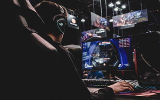 Person sitting on game chair while playing video game