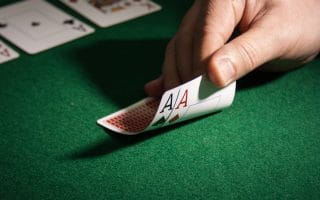 A hand holding two axes cards on a table