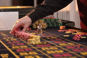 A man picking up poker chips in a casino 