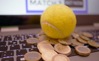 Laptop, coins and a tennis ball