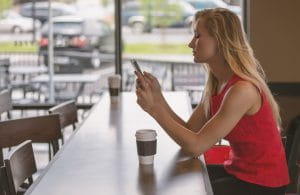 Woman looking at her phone in a coffee shop