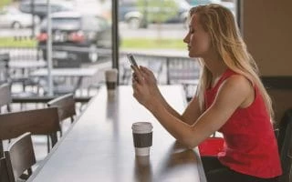 Woman looking at her phone in a coffee shop
