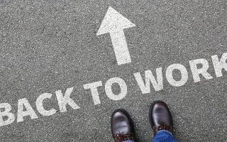 Back to Work Sign on the Road with an Arrow and Person’s Feet Towards It