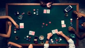 A Shot Over a Table Where Five People Are Playing Poker 