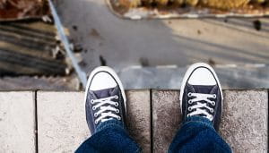 A Person’s Feet on the Edge of a Building Looking Down from the Roof 
