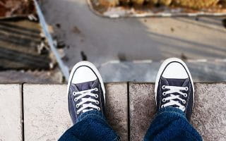 A Person’s Feet on the Edge of a Building Looking Down from the Roof