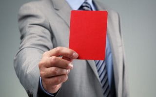 A Person in a Suit Holding a Red Card