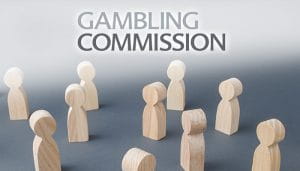 Gambling Commission Logo Over Wooden Figurines