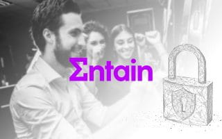 Entain Logo Next to a Padlock on a Blurry Casino Hall Background