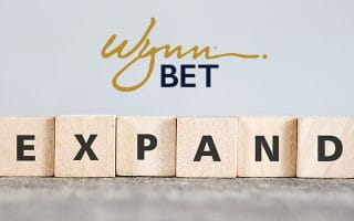 WynnBet Logo Over the Word Expand Written with Scrabble Letters
