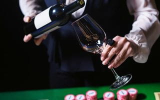 Casino Restaurant Staff Pooring Wine Over a Casino Table