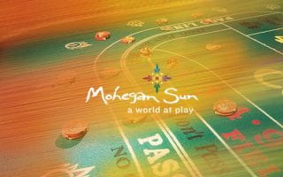 Mohegan Sun Casino Logo Over a Gambling Table with Chips on It