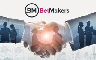 BetMakers Logo over a Picture of Businessmen Shaking Hands