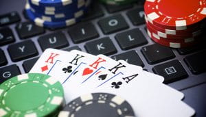 A Laptop Keyboard Covered with Casino Chips and Cards 