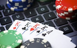 A Laptop Keyboard Covered with Casino Chips and Cards