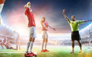 Soccer players surround the referee to complain about a decision