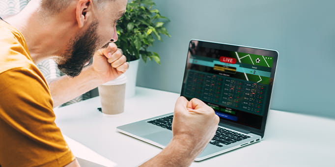 A man staring at a sportsbook on his computer