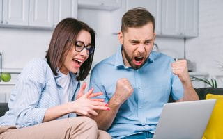 Happy Sports Betting Fans Looking at a Laptop