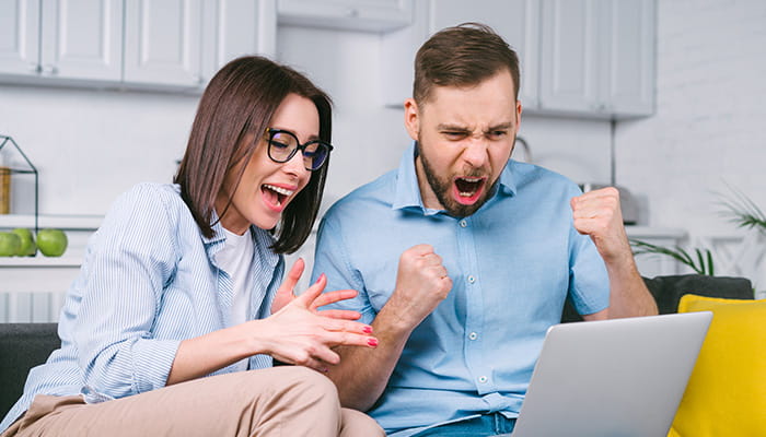 Happy Sports Betting Fans Looking at a Laptop 