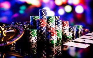 Gambling Elements Like Chips and Cards on a Shiny Surface Inside a Blurred Casino