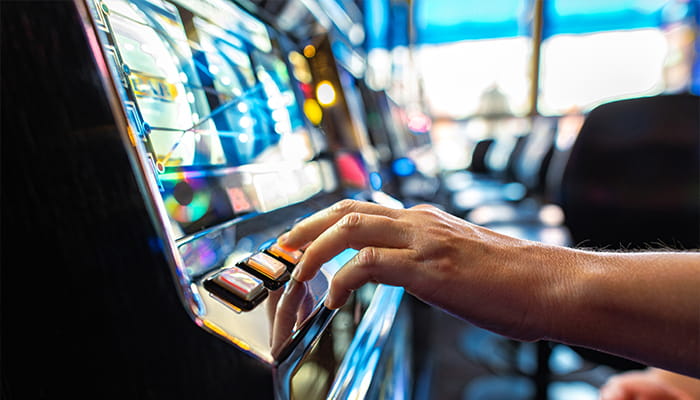 A Hand of a Gambler Playing Slots Inside of a Casino