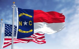 The Flags of North Carolina and the US on Poles in the Wind