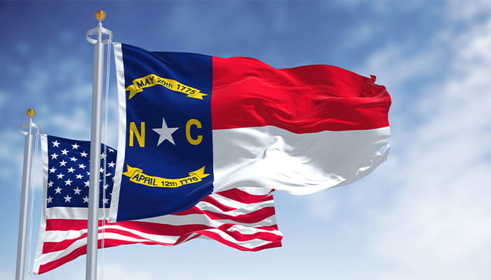 The Flags of North Carolina and the US on Poles in the Wind