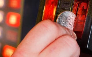 Person Putting Coin into Slot