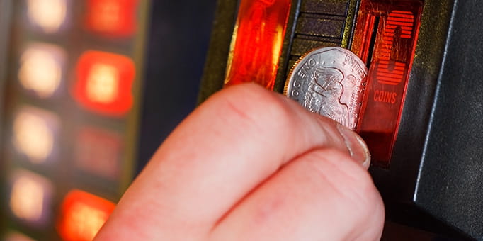 Person Putting Coin into Slot