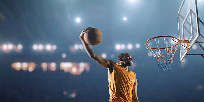 A basketball player scoring a slam dunk in a game