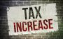 Tax increase wording painted on a brick wall