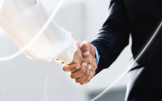Two hands holding partnership puzzle pieces