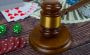 A judge’s hammer next to cards and dice