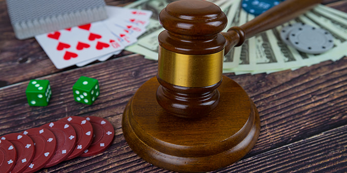 A judge’s hammer next to cards and dice