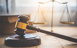 A gavel with books in the background